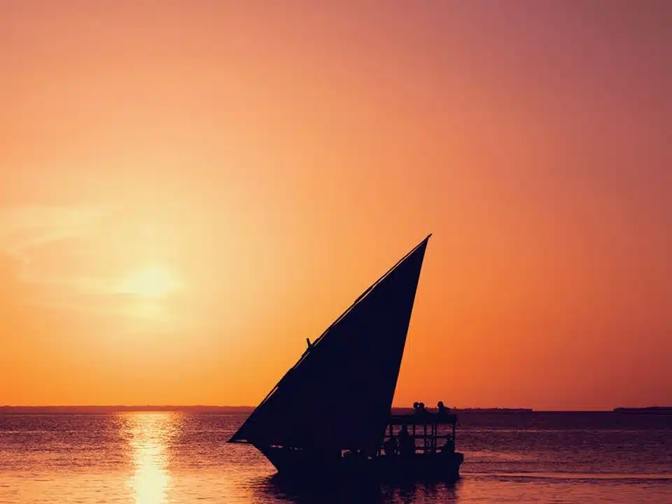 Coucher de soleil à Nungwi, Zanzibar : un dhow navigue sur le lagon au crépuscule