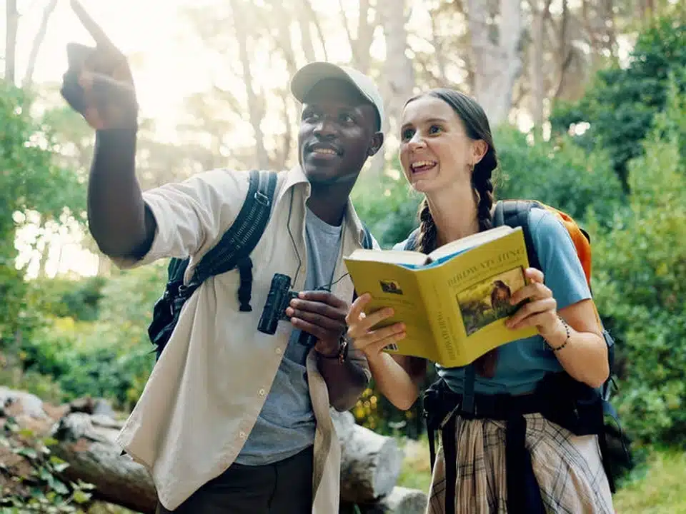 Guide local accompagnant une voyageuse lors d’une observation d’oiseaux en Tanzanie, pendant un safari nature