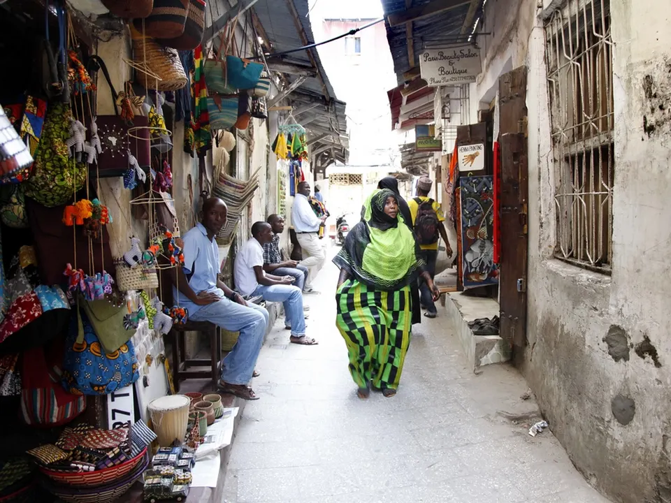 Rue animée de Stone Town avec boutiques et habitants, Zanzibar